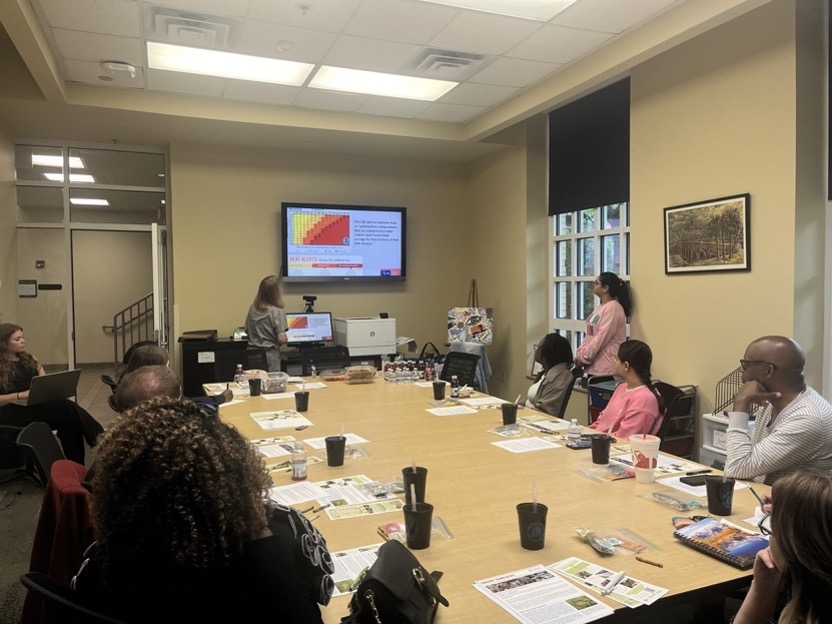 Image of group of people sitting around a table looking at a screen during ocus group session